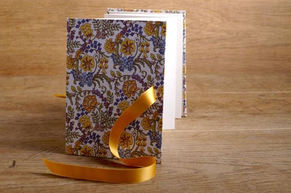Leporello open, light pages, floral cover, satin bow mustard yellow
